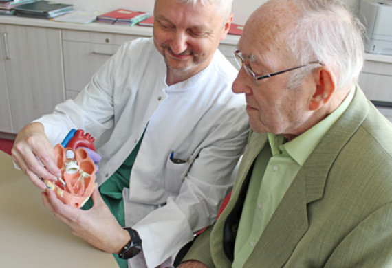 OA Schönweiß zeigt Werner Milde, wo die kleine Kapsel im Herzen eingesetzt wurde. 