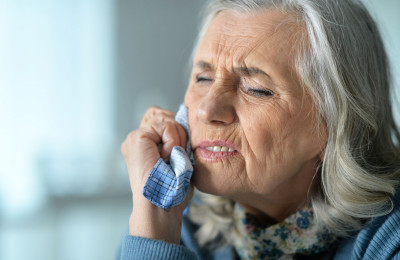 Starke Kopfschmerzen und ein herabhängender Mundwinkel können u.a. ein Alarmzeichen für einen Schlaganfall sein.