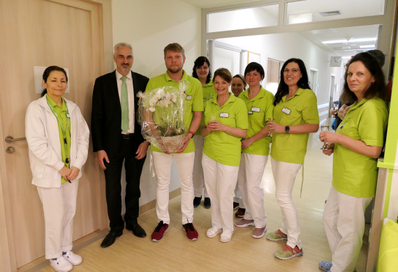 Geschäftsführer der HBK-Poliklinik Michael Kamolz überreicht dem Praxisteam ein Willkommensgeschenk.
